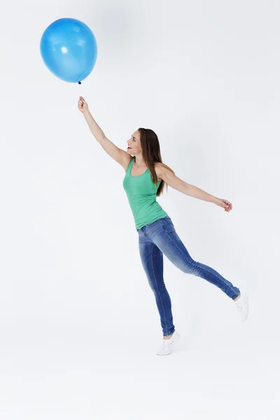 Young woman holding floating balloon