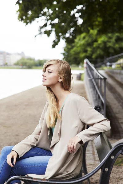 Krásná žena na lavičce — Stock fotografie