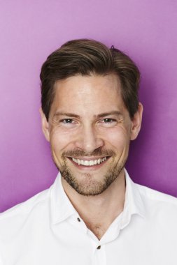 Gülümseyen Adam kameraya bakıyor.