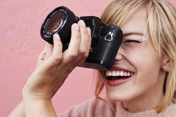 Woman focusing camera and smiling — Stock Photo, Image