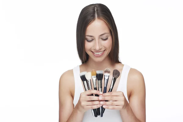 Mujer mirando pinceles de maquillaje — Foto de Stock