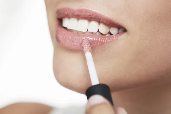 Mujer aplicando brillo labial — Foto de Stock