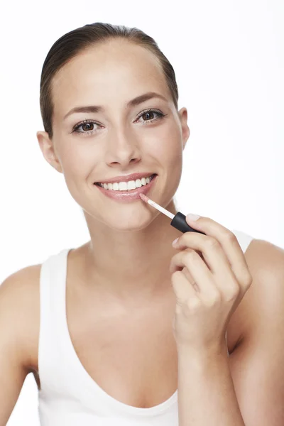 Mujer aplicando brillo labial — Foto de Stock