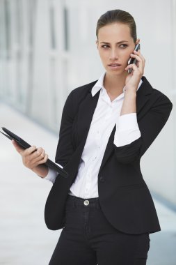 İş kadını cep telefonu kullanıyor.