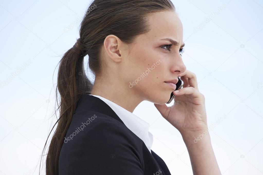 Businesswoman with cellphone looking away