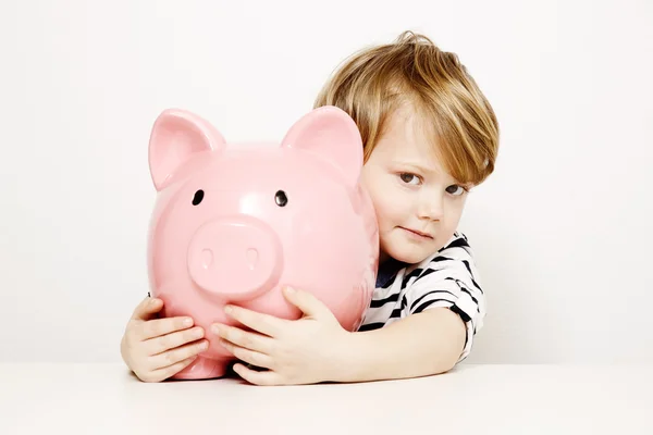 Junge lächelt mit großem Sparschwein — Stockfoto