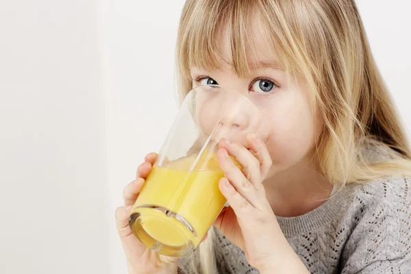 Menina beber suco de laranja — Fotografia de Stock