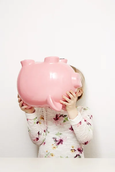 Menina segurando grande porquinho banco — Fotografia de Stock