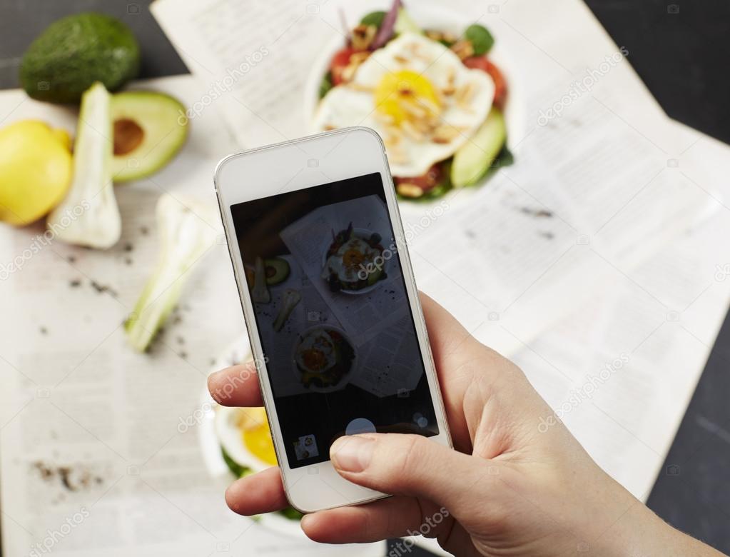 Woman taking photograph of meal