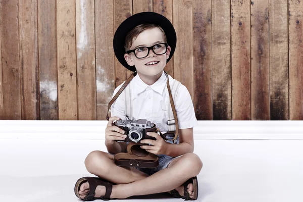 Boy sitting on floor with camera — Stock Photo, Image