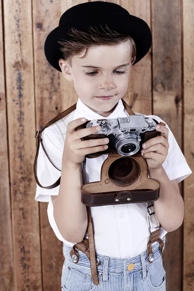 Мальчик смотрит на старую камеру — стоковое фото