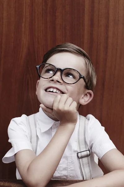 Мальчик в очках смотрит вверх — стоковое фото