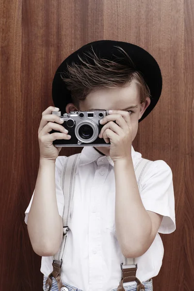 Мальчик фотографируется со старым фотоаппаратом — стоковое фото