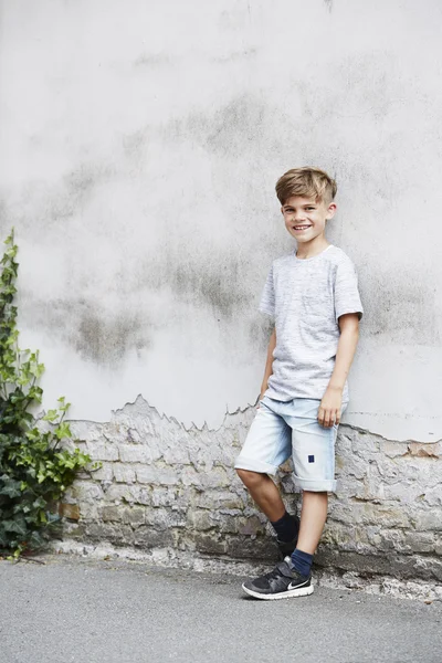 Boy leaning against wall — Stock Photo, Image