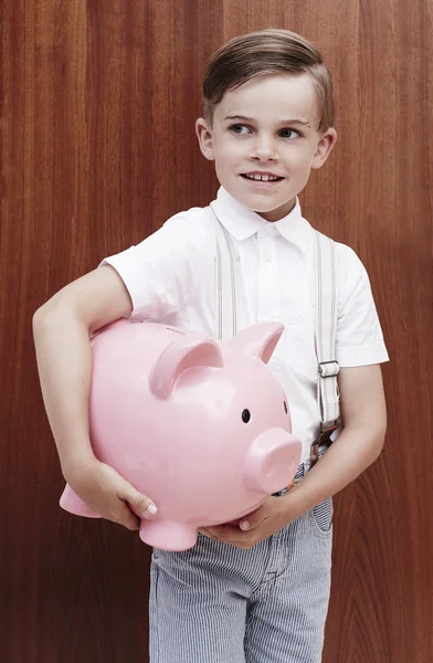 Junge in Zahnspange hält Sparschwein — Stockfoto