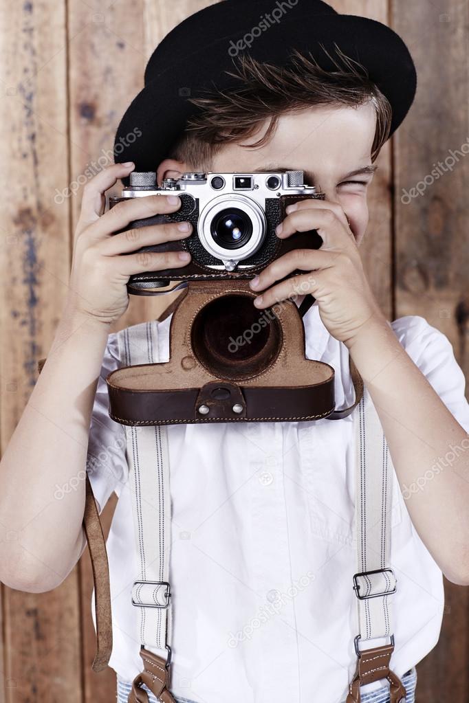 Boy taking photograph with old camera