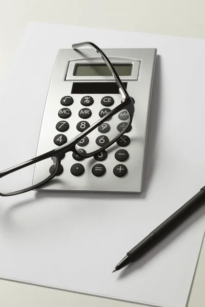 Калькулятор, ручка і окуляри — стокове фото