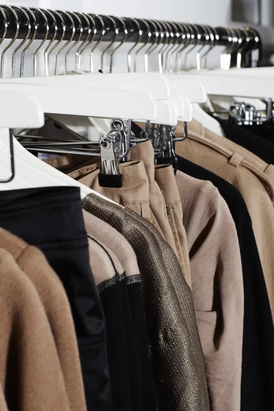 Clothes in a row on coat hangers — Stock Photo, Image