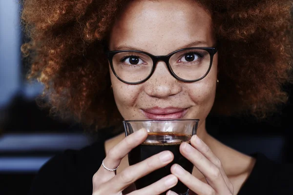 Женщина улыбается за чашкой кофе — стоковое фото