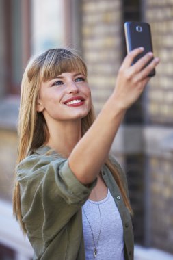 Genç bir kadın selfie çekiyor.