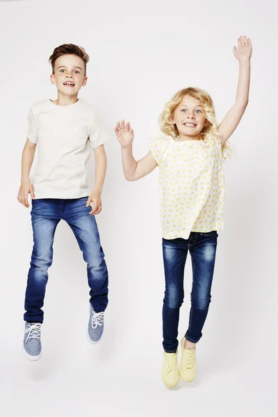 Excited brother and sister jumping — Stock Photo, Image