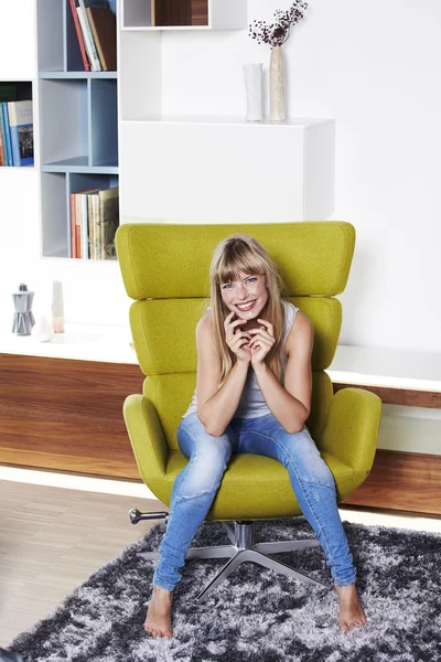 Mulher senta-se na cadeira designer — Fotografia de Stock