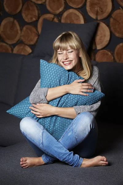 Woman laughing on sofa — Stock Photo, Image