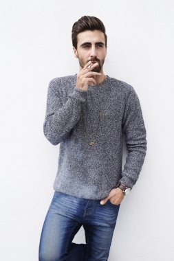 Genç adam sigara içiyor.