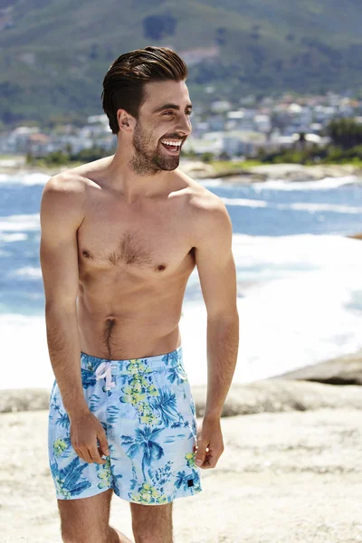 Mladý muž v šortkách na pláži — Stock fotografie