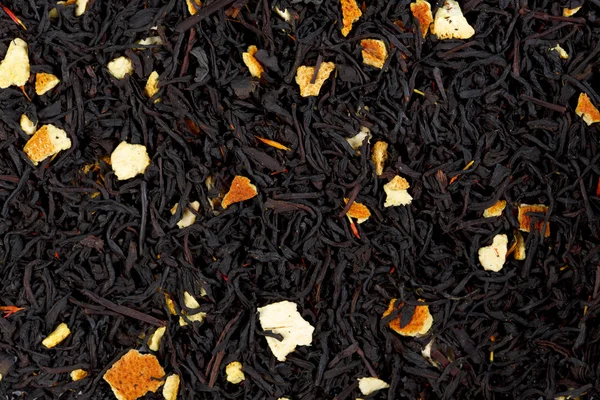 Hintergrund Textur von schwarzem Tee mit Orangenschalen. — Stockfoto