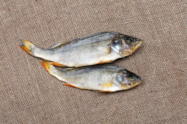 Deux poissons séchés sur la toile de jute gros plan . — Photo