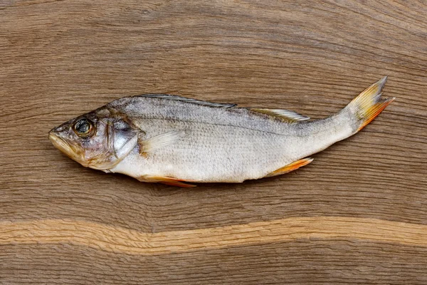 Pesce di fiume secco e salato (persico, spigola) su uno sfondo di legno impressionante — Foto Stock