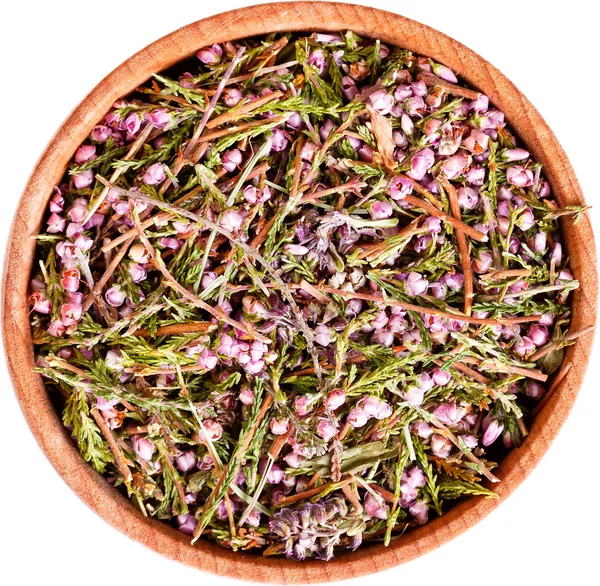 Heather blossom tea in a small wooden bow isolated on white. — Stock Photo, Image