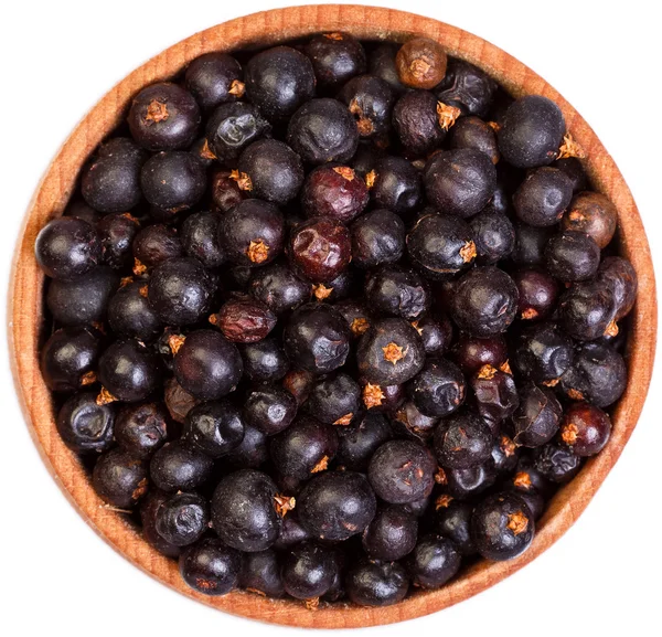 Dried Juniper berries in a small wooden bow isolated on white. — Stock Photo, Image