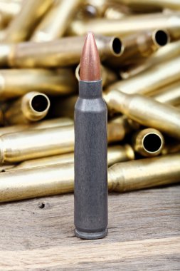 Close-up photo of bullet on the wooden table.
