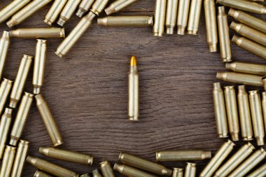 M-16 bullet on wooden table close-up. clipart