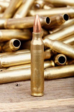 Close-up photo of bullet on the wooden table.