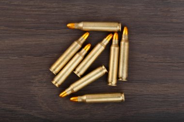 Fire arm bullet cartridges on a old wooden floor. clipart