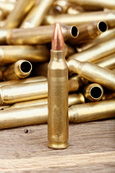 Close-up photo of bullet on the wooden table. — Stockfoto