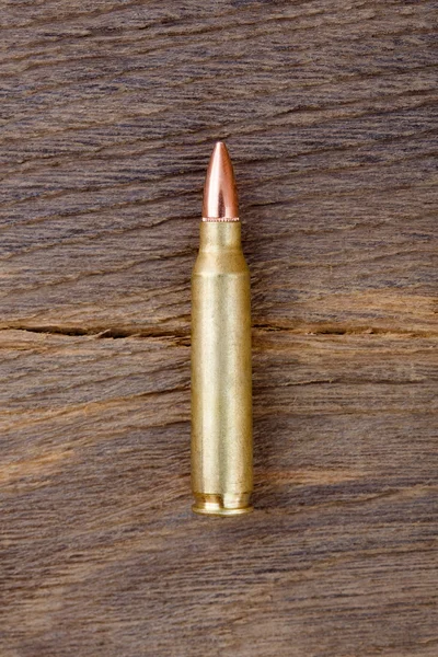 Detailní záběr z puškové bulety na starém dřevěném stole. — Stock fotografie