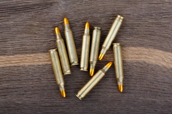 Gewehrkugeln auf altem Holztisch. — Stockfoto