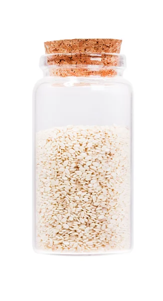 Sesame seeds in a glass bottle with cork stopper, isolated on wh — Zdjęcie stockowe
