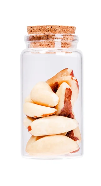 Brazil nuts in a glass bottle with cork stopper, isolated on whi — Stock fotografie