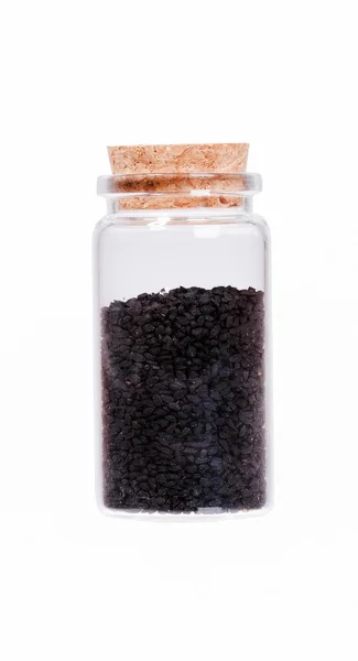 Nigella o comino negro en una botella de vidrio con tapón de corcho, isol —  Fotos de Stock