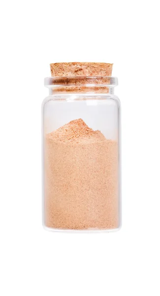 Ground Cinnamon in a glass bottle with cork stopper, isolated on — Stok fotoğraf