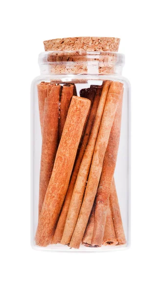 Cinnamon in a glass bottle with cork stopper, isolated on white. — Stock Photo, Image