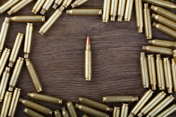 Balas de rifle en la mesa de madera con escena de bajo perfil. Foto de primer plano . — Foto de Stock