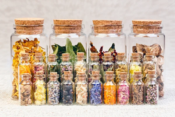 Healing herbs and tinctures in bottles on sackcloth, dried flowe — Stock Photo, Image