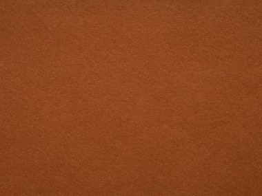 Tarçın renginde bir keçe yüzeyi görüntüsü sıcacık bir sıcaklık yayar, sonbahar baharatlarını ve basit bir dokudaki sade ev konforunu hatırlatır..