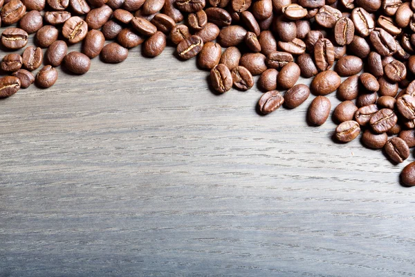 Pražená kávová zrna na dřevě. — Stock fotografie